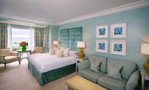 a bedroom with a bed and a couch and a chair at Roslin Beach Hotel in Southend-on-Sea
