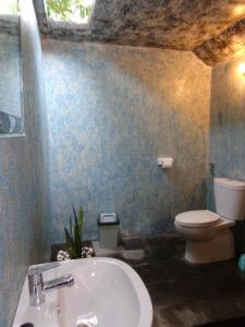uma casa de banho com um WC branco e um lavatório. em Family Bungalow em Gili Air