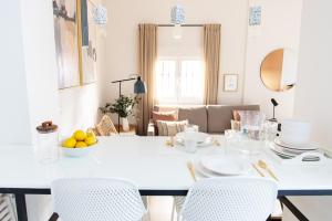 ein weißes Esszimmer mit einem weißen Tisch und Stühlen in der Unterkunft Tinto Townhouse by Olala Homes in Sevilla