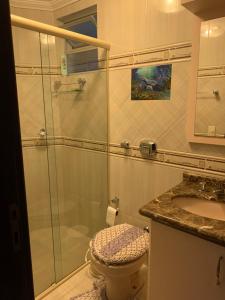 uma casa de banho com um chuveiro, um WC e um lavatório. em Apartamento em itapema em Itapema