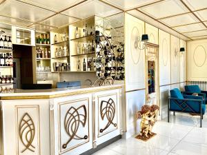 a bar in a room with a blue chair and a counter at Parvana Hotel in Gyumri