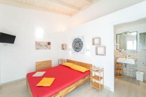 a bedroom with a red bed and a sink at Capriccio Mediterraneo in Sassari