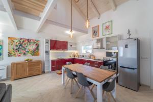 a kitchen with a wooden table and a refrigerator at Capriccio Mediterraneo in Sassari