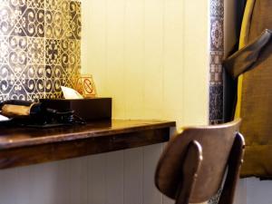 a chair in front of a table with a mirror at Montree Phuket Hotel in Phuket Town