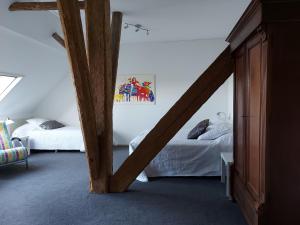 a attic bedroom with two beds and a wooden beam at Piaam State in Piaam