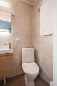 ein Badezimmer mit einem weißen WC und einem Waschbecken in der Unterkunft 8 SEASONS in Varangerbotn