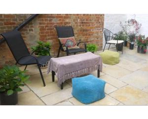 a patio with two chairs and a table with a blanket at The Osney Arms Guest House in Oxford