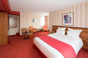 a hotel room with a large bed and a table at Le Jean-Sébastien Bach in Strasbourg