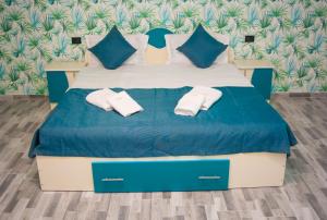 a bedroom with a bed with two white towels on it at CASA ERk in Călimăneşti +93 photos