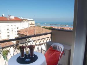a table and chair on a balcony with a view of the ocean at Residence I Girasoli in Rimini
