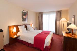 a hotel room with a large bed and a window at Le Jean-Sébastien Bach in Strasbourg