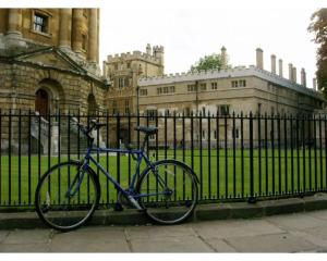 una bicicletta parcheggiata accanto a una recinzione di fronte a un edificio di The Osney Arms Guest House a Oxford