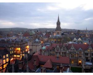 vista su una città di notte con torre dell'orologio di The Osney Arms Guest House a Oxford