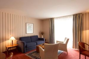 a living room with a blue couch and a table at Le Jean-Sébastien Bach in Strasbourg