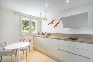 a kitchen with a white counter and a table at Giovannina N2 in Cassis