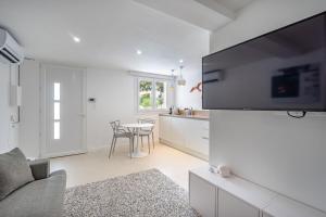 eine Küche und ein Wohnzimmer mit einem TV an der Wand in der Unterkunft Giovannina N2 in Cassis