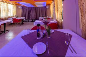 霍斯佩特KSTDC Hotel Mayura Vijayanagara Hampi的用餐室配有带白色盘子和餐具的桌子