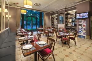 a restaurant with tables and chairs and a large window at Green Court Residence City Center, Shanghai in Shanghai