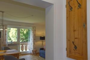 uma sala de estar com uma porta e uma janela em Arnspitzgarten em Mittenwald