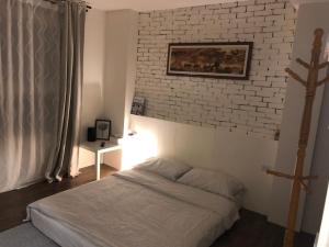 um quarto com uma cama e uma parede de tijolos em 光鹿旅人短期月租出租 em Tanzi