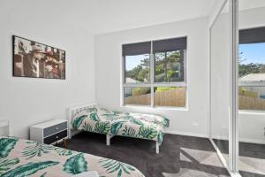a bedroom with two beds and a window at Brand new house, amazing views, walk to the beach! in Kiama