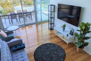 a living room with a large flat screen tv at Brand new house, amazing views, walk to the beach! in Kiama