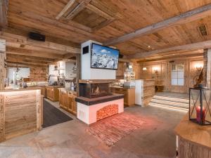 a large kitchen with a fireplace and a flat screen tv at Hotel Pinzger Tux in Tux