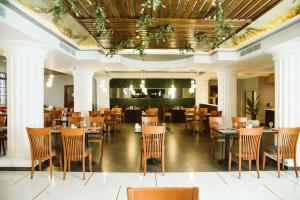 a restaurant with tables and chairs and a ceiling at Pyramisa Suites Hotel Cairo in Cairo