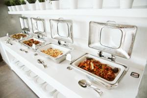 three trays of food on a counter with mirrors at Pyramisa Suites Hotel Cairo in Cairo