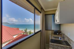 a kitchen with a view of the ocean at Flat Pietra in Florianópolis