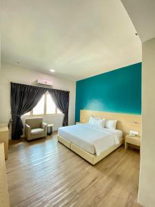 a bedroom with a white bed and a blue wall at Summit Signature Hotel Batu Pahat in Batu Pahat