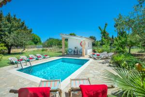 una piscina con sillas y una casa en Owl Booking Villa Guacamayo - Vacation Paradise, en Pollensa
