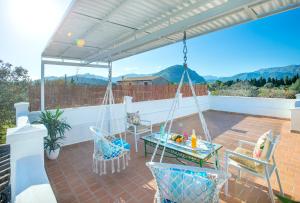 un patio con hamaca, mesa y sillas en Owl Booking Villa Guacamayo - Vacation Paradise, en Pollensa