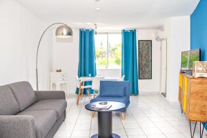 uma sala de estar com um sofá e uma mesa em L Art est Union - joli T1 à 5min à pied de la plage de Boucan Canot em Saint-Gilles-les-Bains