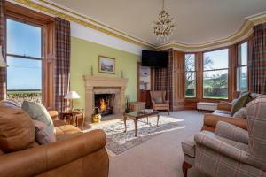 a living room filled with furniture and a fireplace at Easter Kincaple Farmhouse, Sleeps 16, St Andrews in St Andrews