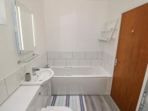 une salle de bain blanche avec une baignoire et un lavabo dans l'établissement Berth, à Pwllheli 24 autres photos