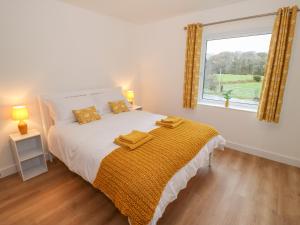 une chambre avec un grand lit avec une fenêtre dans l'établissement Berth, à Pwllheli