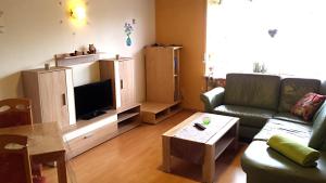 a living room with a couch and a tv at Monteurunterkunft Haus Barbara Pirmasens in Pirmasens