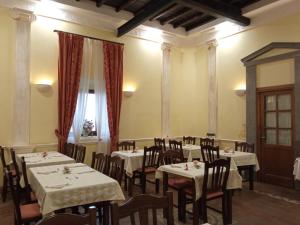 Casale Certosa في Pavona: غرفة طعام بها طاولات وكراسي ونافذة
