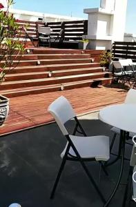 two white chairs and a table on a deck at Hotel Rex in Piriápolis