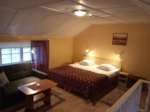 une chambre d'hôtel avec un lit et un canapé dans l'établissement Repo Hotel, à Kuressaare