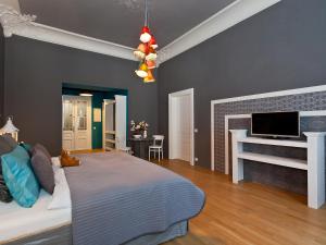 a bedroom with a bed and a tv on a wall at Royal Prague City Apartments in Prague