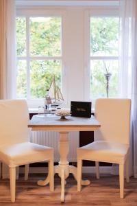 een tafel met twee stoelen en een laptop erop bij Hotel Hof Holm in Brasilien