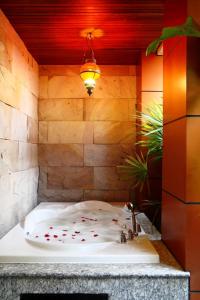 a bathroom with a bath tub with a sink at The Fusion Suites in Bangkok