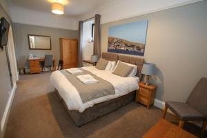 a bedroom with a large bed and a chair at The Royal Hotel in Stromness