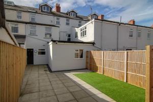 a backyard with a fence and green grass at New Luxury Apt 1 Free Parking Special Deals in Blackpool
