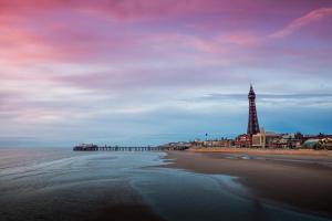 een uitzicht op een strand met een pier en een vuurtoren bij 2 Bedrooms Sleeps 7 Near Top Blackpool Attractions in Blackpool +12 foto's