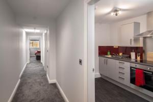 een keuken met witte kasten en een lange hal bij 2 Bedrooms Sleeps 7 Near Top Blackpool Attractions in Blackpool