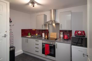 a kitchen with white cabinets and a stove top oven at 2 Bdrm Sleeps 7 Near Top Attractions Free Parking in Blackpool