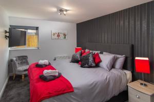 1 dormitorio con 1 cama grande con mantas rojas en New Luxury Apt 1 Free Parking Special Deals, en Blackpool